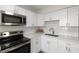 Modern kitchen with stainless appliances, white cabinets, and quartz countertops at 1974 N Betty Ln, Clearwater, FL 33755