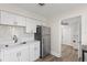 Well lit kitchen with white cabinetry, stainless steel appliances and view of a utility room at 1974 N Betty Ln, Clearwater, FL 33755