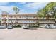 Multi-level condo complex with ample parking, mature trees, and well-maintained facade under a sunny sky at 2310 Denmark St # 30, Clearwater, FL 33763