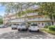 View of a community building featuring ample parking spaces and well-maintained landscaping at 2310 Denmark St # 30, Clearwater, FL 33763