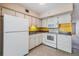 Kitchen with appliances, bright counters, yellow backsplash, and tile flooring at 2310 Denmark St # 30, Clearwater, FL 33763