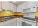 Charming kitchen featuring white cabinets, laminate countertops, and modern appliances at 2310 Denmark St # 30, Clearwater, FL 33763