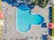 Aerial view of a uniquely shaped pool with lounge chairs and brick-style deck area at 2310 Denmark St # 30, Clearwater, FL 33763