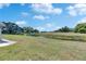 A lovely view of the green backyard lawn and pond showing the house in the distance on a sunny day at 2313 Grenoble Pl # 2313, Sun City Center, FL 33573
