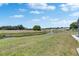 A beautiful backyard view shows the pond on a green lawn with other homes in the distance on a sunny day at 2313 Grenoble Pl # 2313, Sun City Center, FL 33573