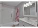 Bathroom with white tiling, white sink and vanity and red and pink shower curtain at 2313 Grenoble Pl # 2313, Sun City Center, FL 33573