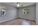 Bright bedroom featuring wood-look floors and a ceiling fan, complemented by natural light from two windows at 2313 Grenoble Pl # 2313, Sun City Center, FL 33573