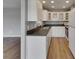 Bright kitchen featuring white cabinetry, modern appliances, and hardwood flooring at 2313 Grenoble Pl # 2313, Sun City Center, FL 33573