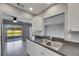 Kitchen with white cabinets and stainless steel appliances, open to the covered patio at 2313 Grenoble Pl # 2313, Sun City Center, FL 33573