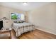 This bedroom features wood floors, neutral walls, great natural light, and a wood dresser set with a TV at 2458 Columbia Dr E # 84, Clearwater, FL 33763