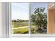 A glimpse of a tranquil lake and walking path from a bright window at 2458 Columbia Dr E # 84, Clearwater, FL 33763