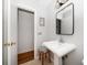Bathroom features a pedestal sink, black framed mirror, and a doorway to an adjacent room at 246 20Th Ne Ave, St Petersburg, FL 33704