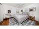 Bedroom with a white and grey striped bed, geometric rug, white walls and plenty of natural light at 246 20Th Ne Ave, St Petersburg, FL 33704