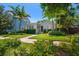 Beautifully landscaped home featuring lush green lawn, tropical plants, and a welcoming entryway at 246 20Th Ne Ave, St Petersburg, FL 33704