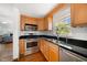 Updated kitchen featuring stainless steel appliances, wooden cabinets, black countertops, and a view to the living room at 246 20Th Ne Ave, St Petersburg, FL 33704