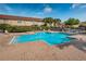 Community pool featuring lounge chairs, a secure fence, and a nearby playground at 2574 Hidden Cove Ln, Clearwater, FL 33763