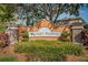 Landscaped Sunset Pointe community sign with mature trees and manicured shrubbery at 2574 Hidden Cove Ln, Clearwater, FL 33763
