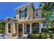 Charming two-story home featuring a covered front porch with decorative columns and lush landscaping at 2574 Hidden Cove Ln, Clearwater, FL 33763