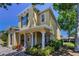 Charming two-story home featuring a covered front porch with decorative columns and lush landscaping at 2574 Hidden Cove Ln, Clearwater, FL 33763