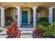 Inviting front porch adorned with columns, a wreath on the door, and vibrant landscaping at 2574 Hidden Cove Ln, Clearwater, FL 33763