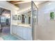 Well-lit bathroom featuring double sinks, a glass-enclosed shower, and views into an adjacent bedroom at 2663 Sequoia Ter # 2663, Palm Harbor, FL 34683
