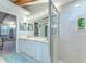Well-lit bathroom featuring double sinks, a glass-enclosed shower, and views into an adjacent bedroom at 2663 Sequoia Ter # 2663, Palm Harbor, FL 34683