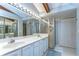 Bright bathroom with double sinks, a glass-enclosed shower, and ample storage space at 2663 Sequoia Ter # 2663, Palm Harbor, FL 34683