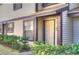 Townhome front entrance with covered porch, neutral siding, and lush landscaping at 2663 Sequoia Ter # 2663, Palm Harbor, FL 34683
