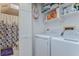 Laundry room featuring washer, dryer, shelving and a half-view into an adjacent bathroom at 2663 Sequoia Ter # 2663, Palm Harbor, FL 34683