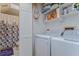 Bright laundry room featuring a washer and dryer, storage shelves and cabinets, and an adjacent bathroom at 2663 Sequoia Ter # 2663, Palm Harbor, FL 34683