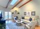 Bright living room featuring vaulted ceilings with wooden beams, skylight, fireplace, and modern furnishings at 2663 Sequoia Ter # 2663, Palm Harbor, FL 34683