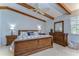 Comfortable main bedroom featuring wooden beams, ceiling fan, and a king-size bed at 2663 Sequoia Ter # 2663, Palm Harbor, FL 34683