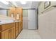 Well-lit bathroom with double sinks, wood cabinetry, and tiled floors; towel racks included at 28628 Twinbrook # Ln, Wesley Chapel, FL 33543
