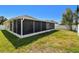 Exterior view of the house showing the screened-in lanai and a spacious backyard at 3015 Azalea Blossom Dr, Plant City, FL 33567