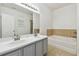 Bathroom boasts double sinks, soaking tub with tile surround, and neutral tile flooring at 3015 Azalea Blossom Dr, Plant City, FL 33567