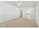 Bright, carpeted bedroom featuring a ceiling fan and access to the ensuite bathroom at 3015 Azalea Blossom Dr, Plant City, FL 33567