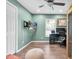 A well-lit bedroom features wood flooring, a ceiling fan, and a wall-mounted TV for comfortable and convenient living at 315 Oakwood Blvd, Oldsmar, FL 34677