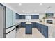 Bright eat-in kitchen with blue cabinets, stainless steel appliances, tile floors, and a center island with butcher block at 315 Oakwood Blvd, Oldsmar, FL 34677