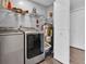 Modern laundry room features a washer, dryer, storage shelves, and fresh gray paint, making chores a breeze at 315 Oakwood Blvd, Oldsmar, FL 34677