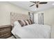 Comfortable bedroom features a large upholstered headboard, ceiling fan, and neutral decor at 315 Oakwood Blvd, Oldsmar, FL 34677
