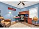 Home office featuring blue walls, hardwood floors, built-in desk, and comfortable seating at 315 Oakwood Blvd, Oldsmar, FL 34677