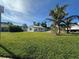 Quaint single-story home surrounded by a green lawn and mature palm trees at 4031 Bay Ne St, St Petersburg, FL 33703