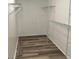 Spacious walk-in closet featuring white shelving and wood-look vinyl floors at 4102 Fox Ridge Blvd, Wesley Chapel, FL 33543