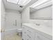 Bright white bathroom features a shower-tub combo and a vanity with generous storage space at 500 Glennes Ln # 205, Dunedin, FL 34698