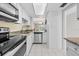 Efficient kitchen with granite countertops, stainless steel appliances, and bright lighting at 500 Glennes Ln # 205, Dunedin, FL 34698