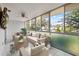 Relaxing sunroom featuring a ceiling fan, tile flooring, and sliding windows with outdoor views at 500 Glennes Ln # 205, Dunedin, FL 34698