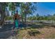 Backyard featuring a playset surrounded by green grass and shady trees providing a fun and relaxing outdoor space at 5153 Bay Blvd, Port Richey, FL 34668