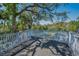 Large outdoor deck with wood planks and white railings surrounded by lush landscaping at 5153 Bay Blvd, Port Richey, FL 34668
