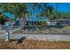 View of a blue home with fresh landscaping, large tree, and an inviting front yard at 5153 Bay Blvd, Port Richey, FL 34668
