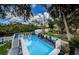 Aerial view of the pool, deck, and surrounding landscape with water views beyond at 5153 Bay Blvd, Port Richey, FL 34668